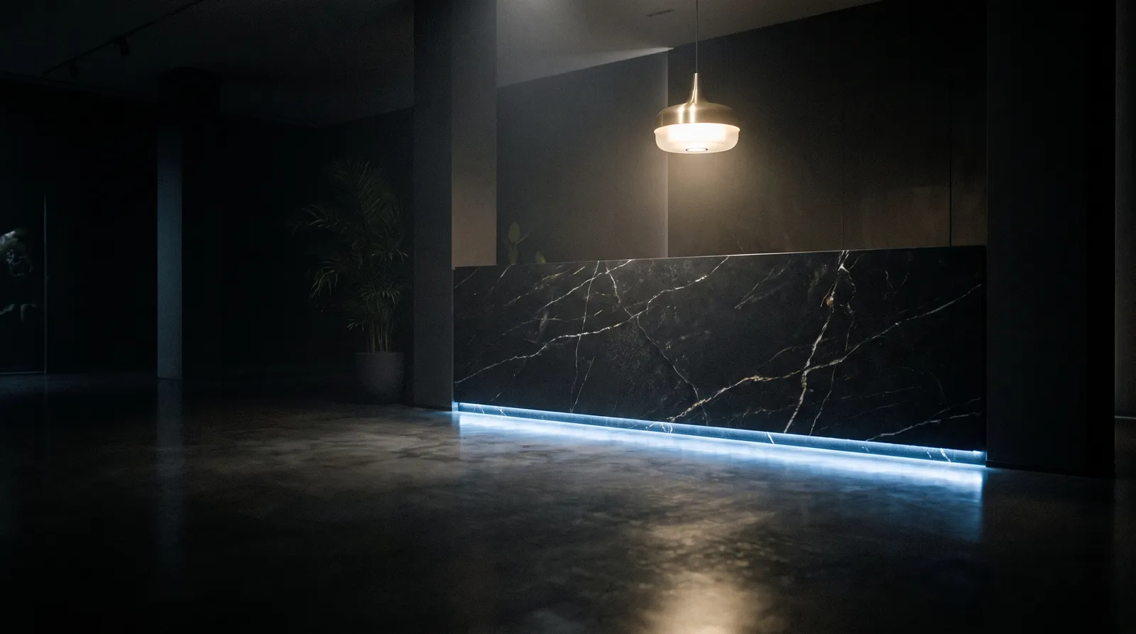 Luxury dental clinic reception desk in dark stone with steel-blue backlight at night