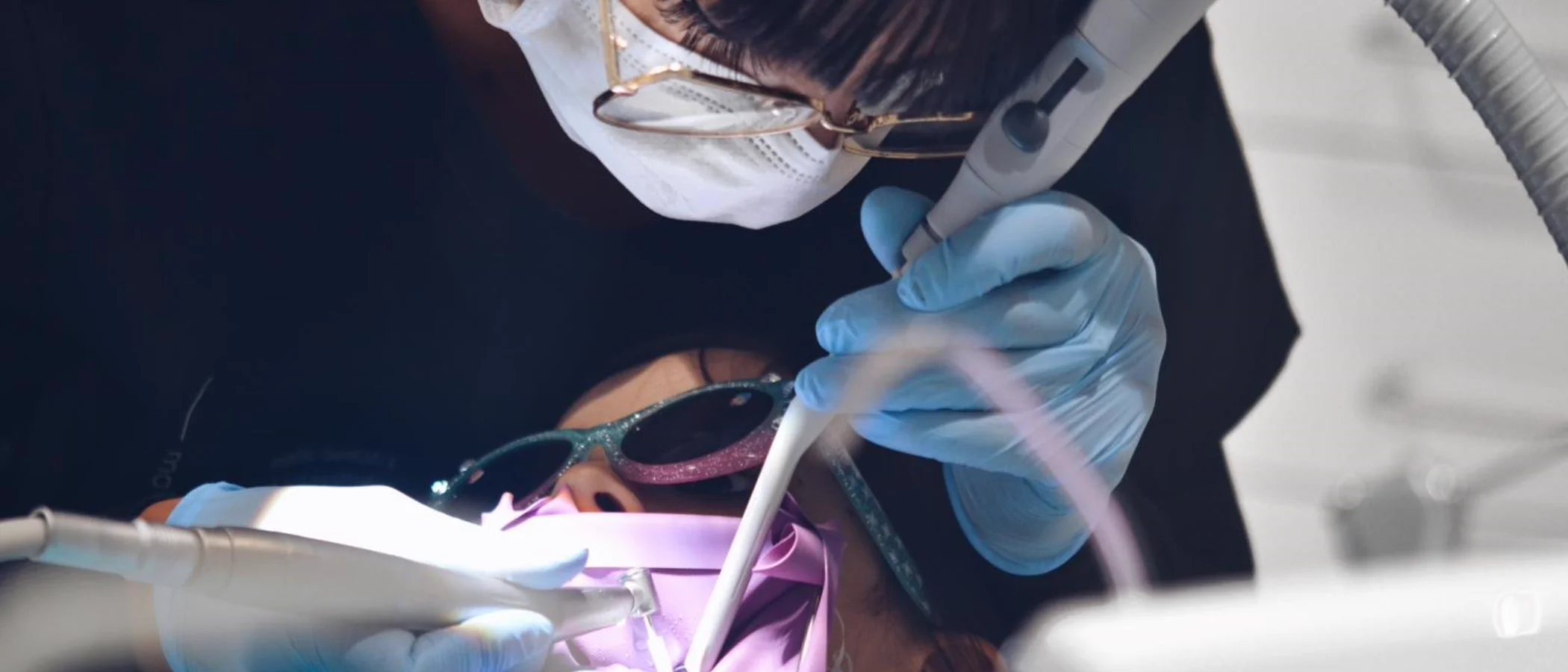 A clinician treats a patient under the dental light at Maida Smiles.