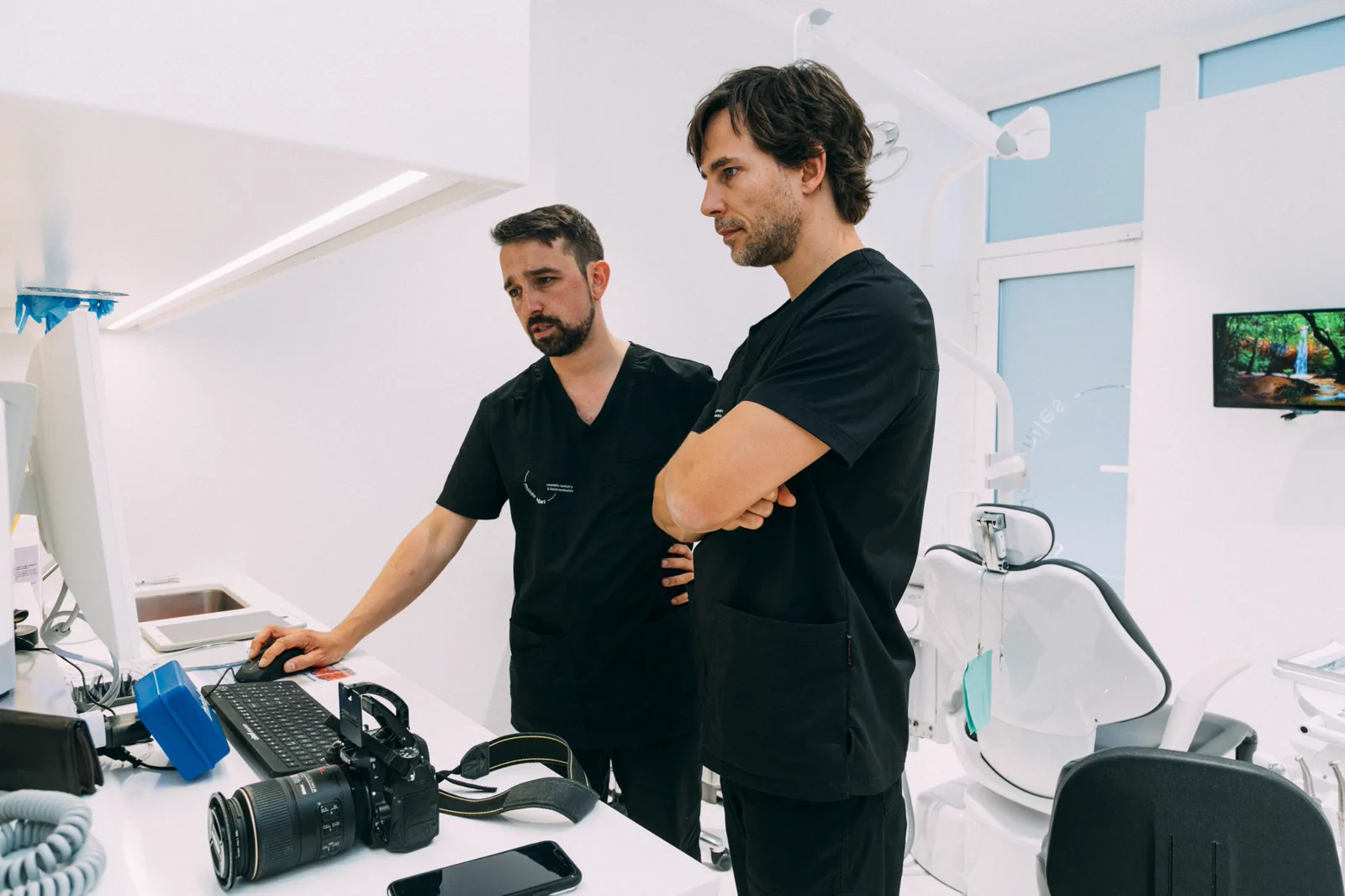 Two clinicians review clinical images together at a Maida Smiles workstation.