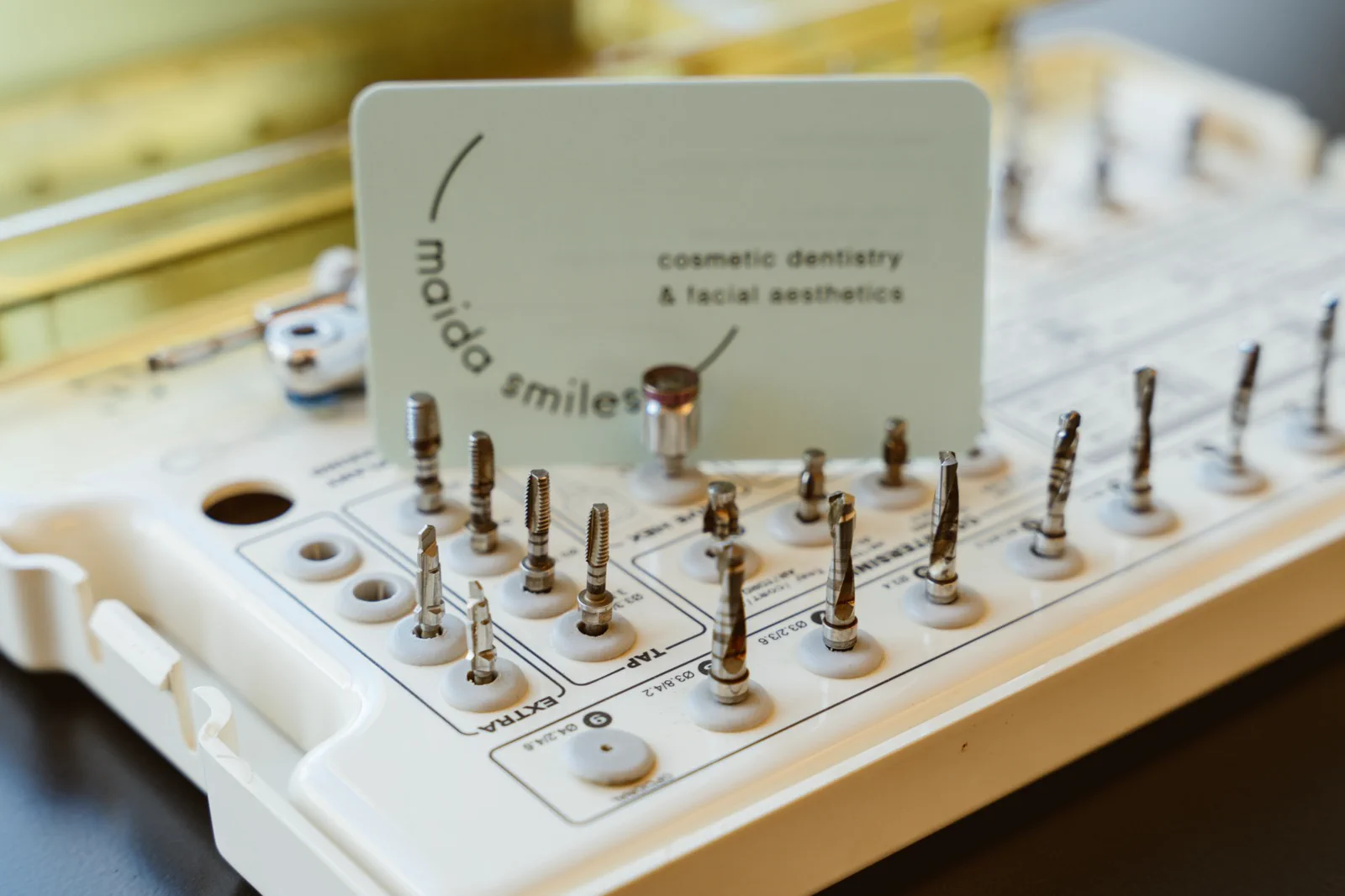 An organised implant surgical kit is displayed with a Maida Smiles card.