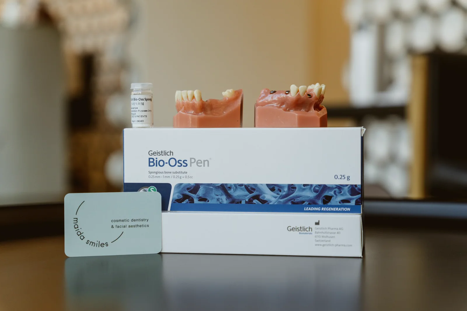 A transparent implant model is displayed with bone regeneration packaging.