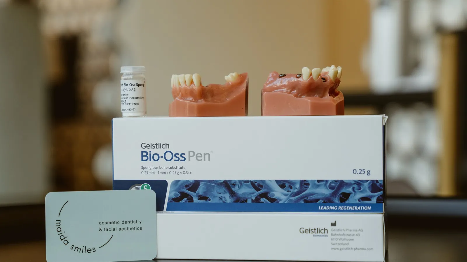 Implant jaw models and Geistlich Bio-Oss Pen bone-regeneration packaging on a clinic table