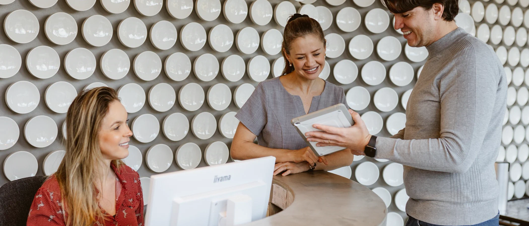 Clinic staff help a patient at the Maida Smiles reception desk.