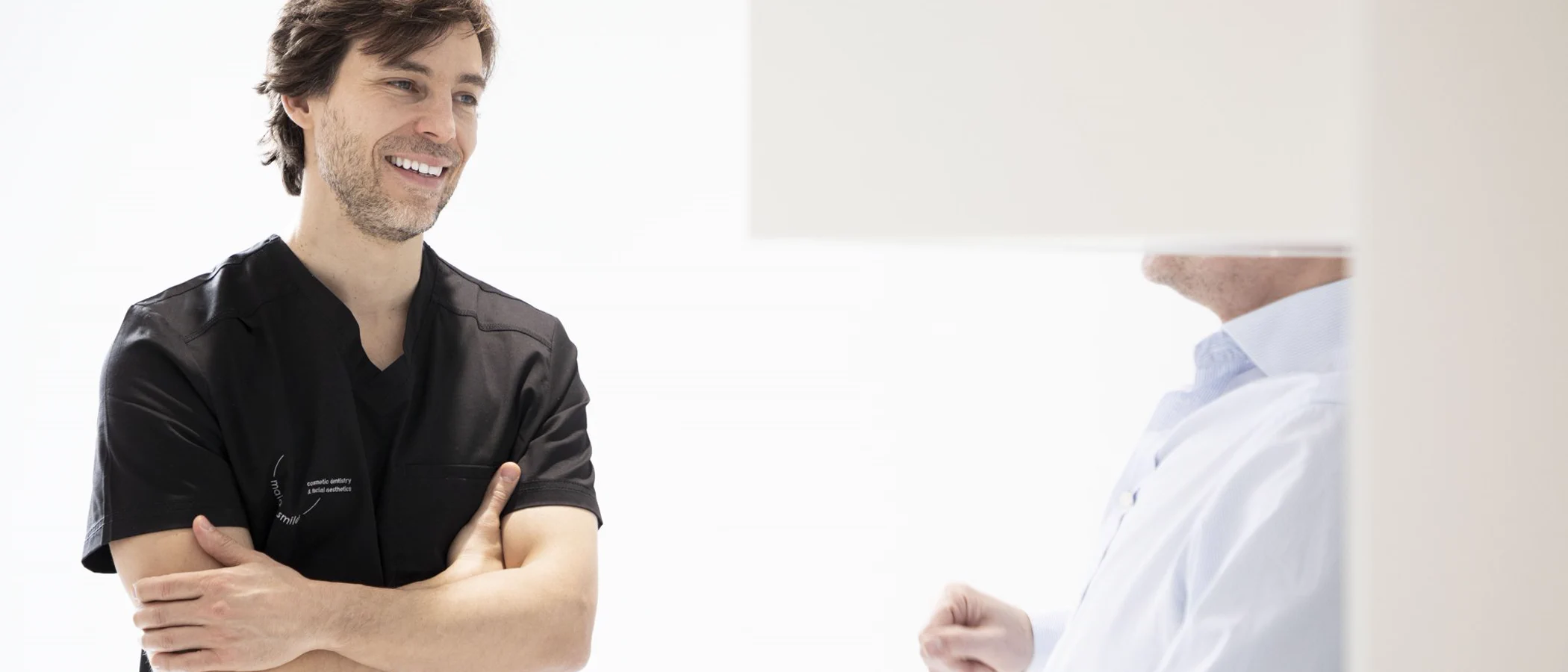 Dentists in Maida Smiles scrubs discuss clinical work together.