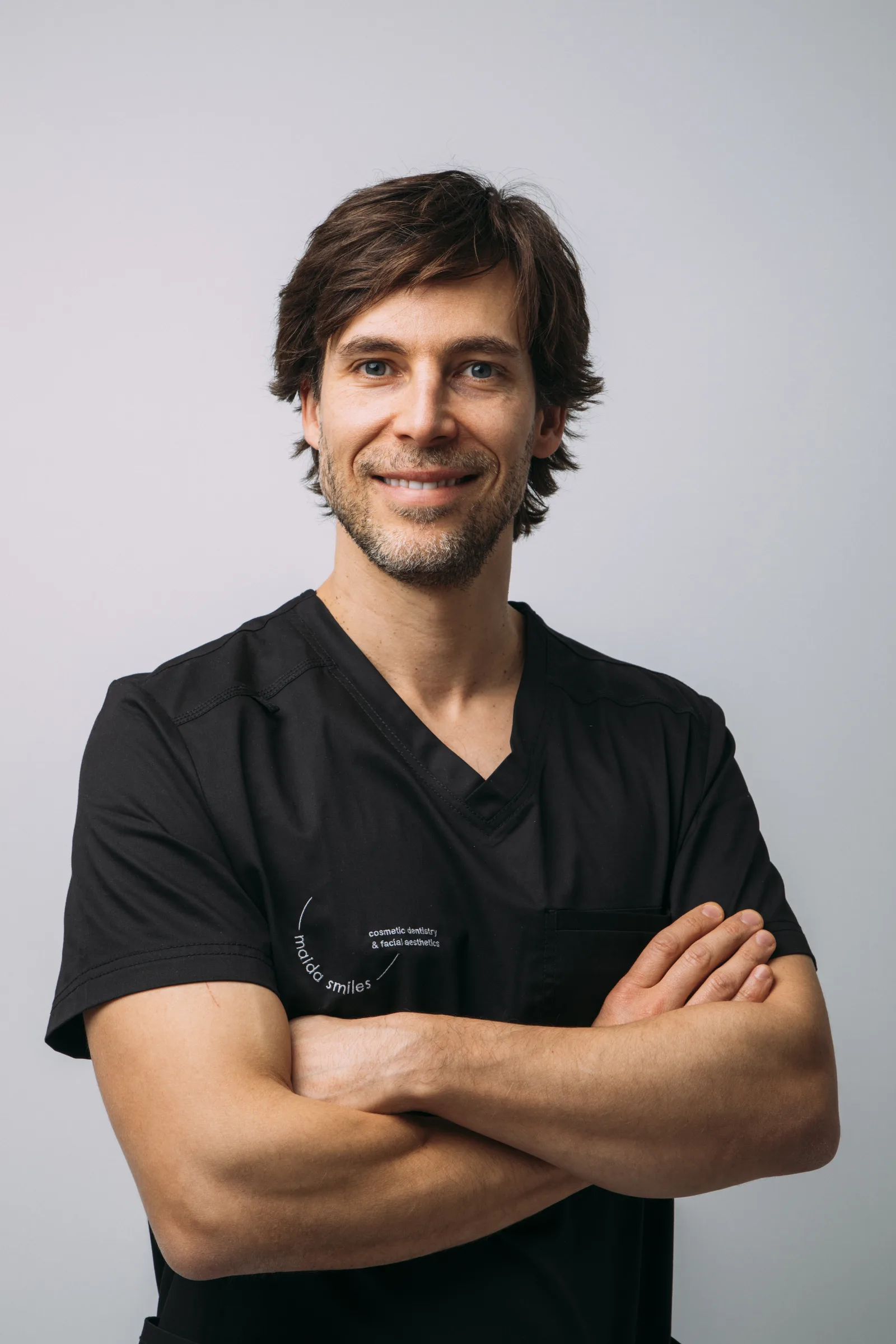 Dr Pedro Gutierres in black surgical scrubs, arms crossed